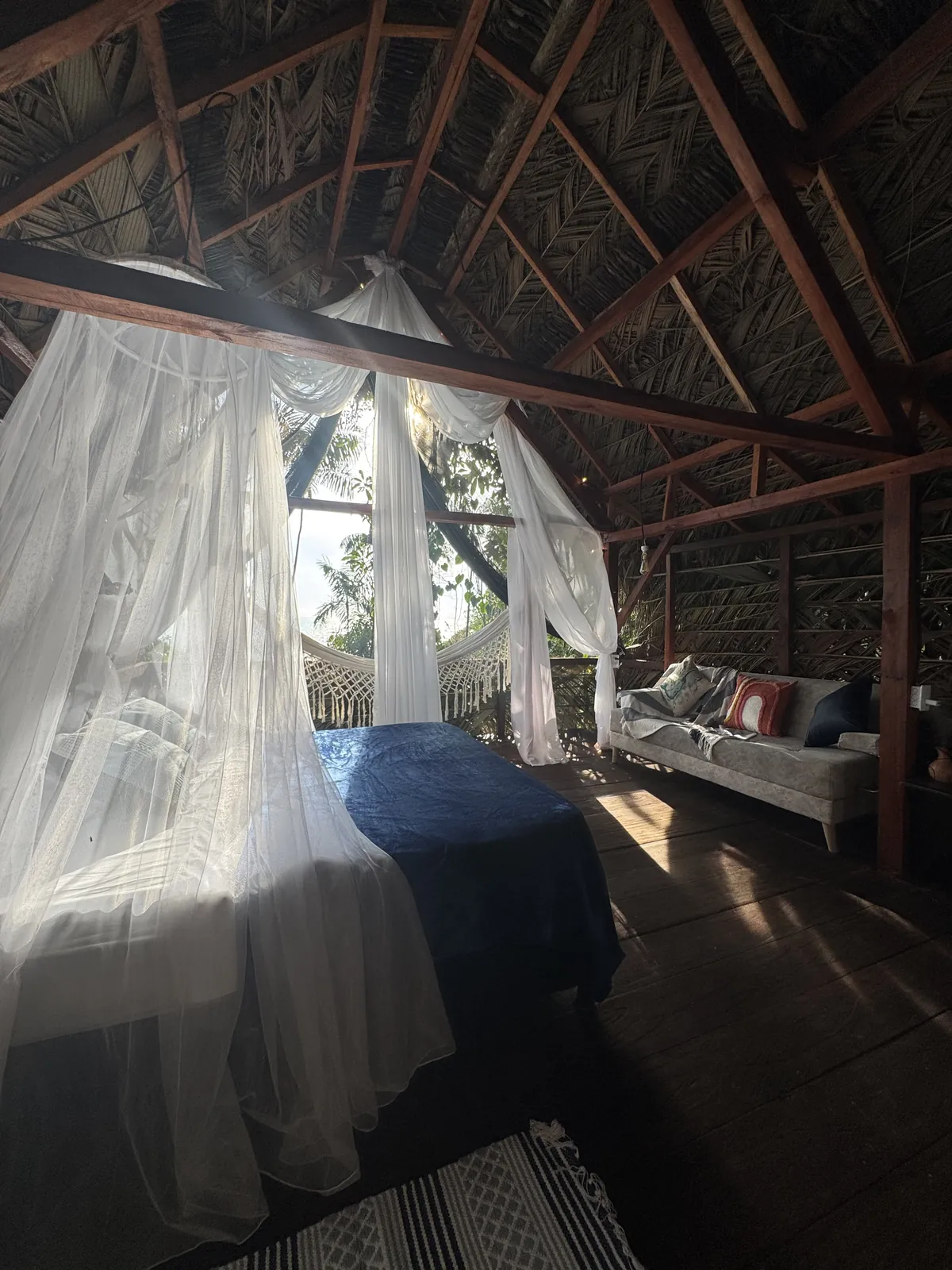 Cama y sofá del Glamping de LUX con luz de mañana
