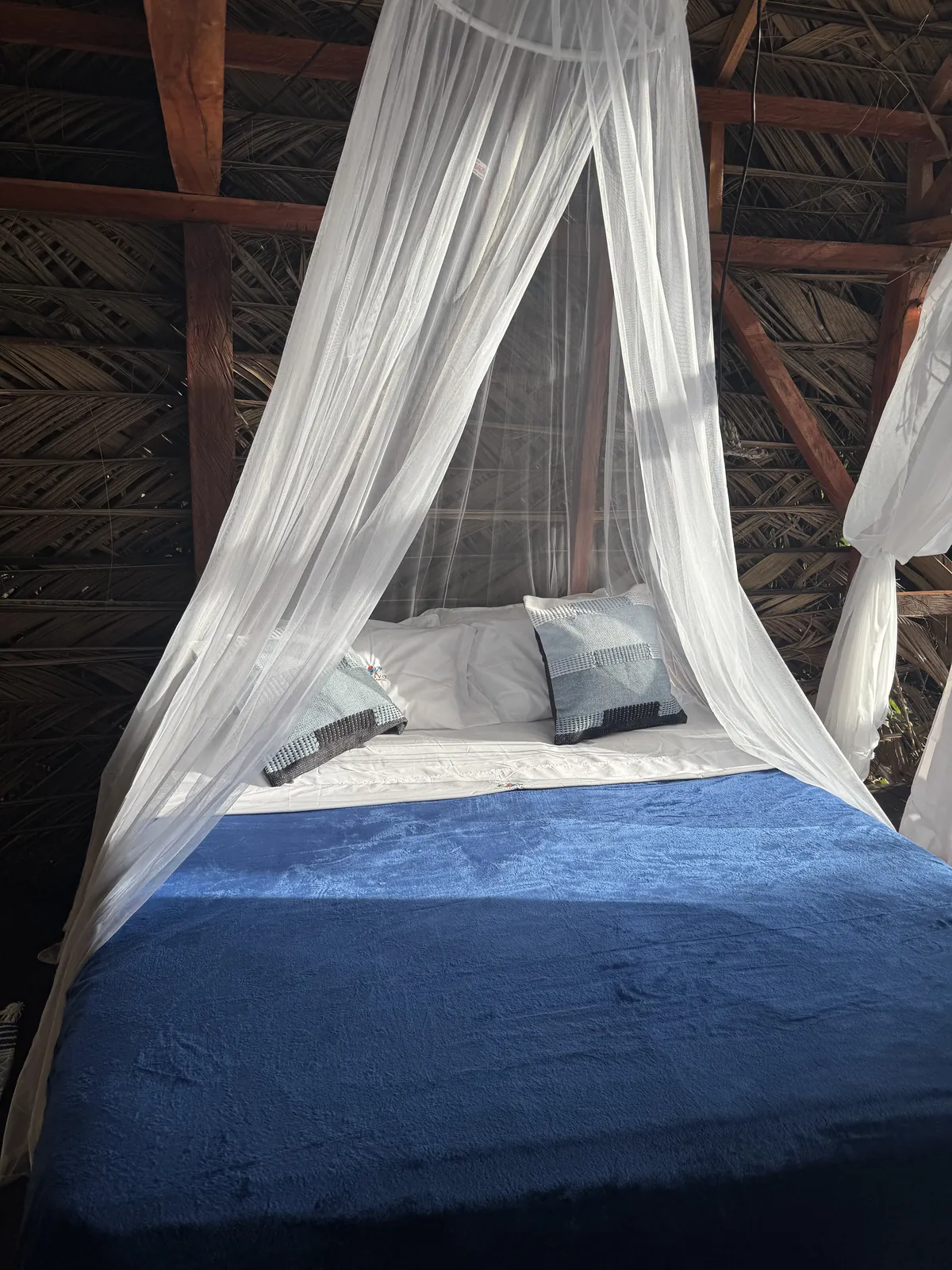Cama doble del Glamping de LUX con toldo blanco