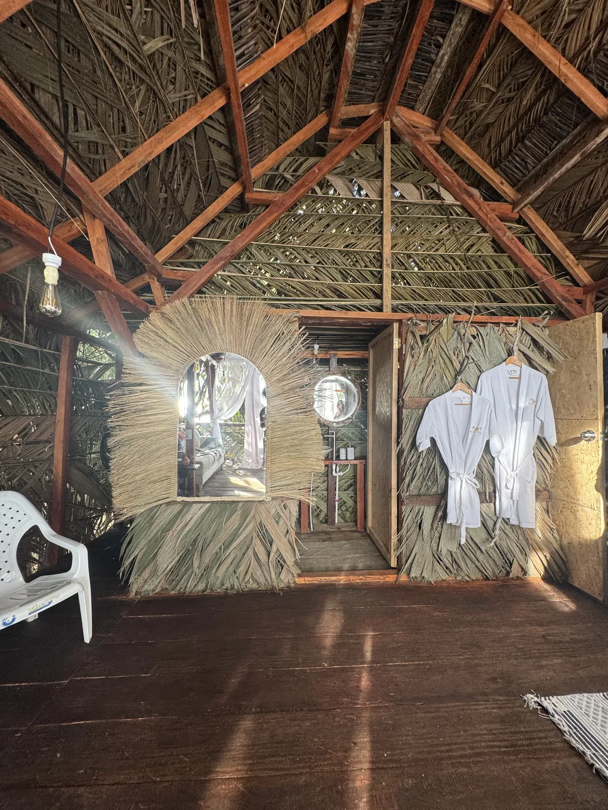 Interior del Glamping de LUX con techo de palma, espejo y batas