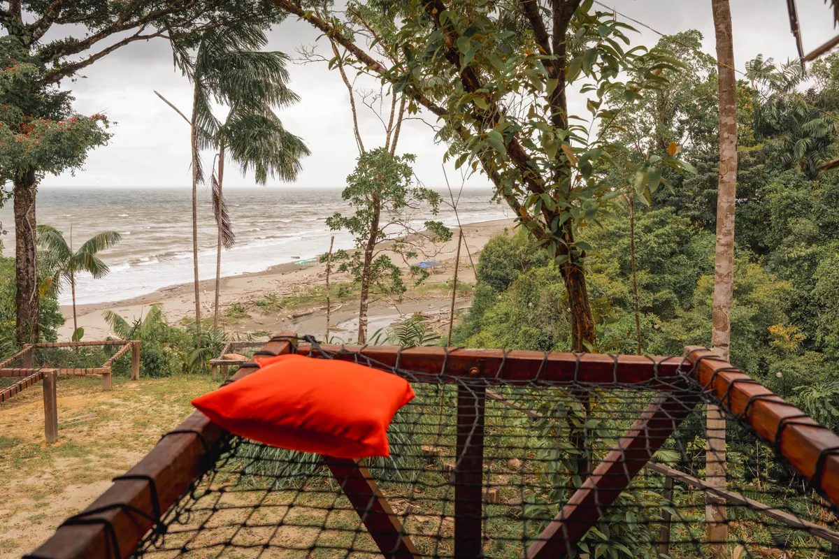 Terraza de malla del Mini Nativo con cojín naranja y vista al mar del Pacífico