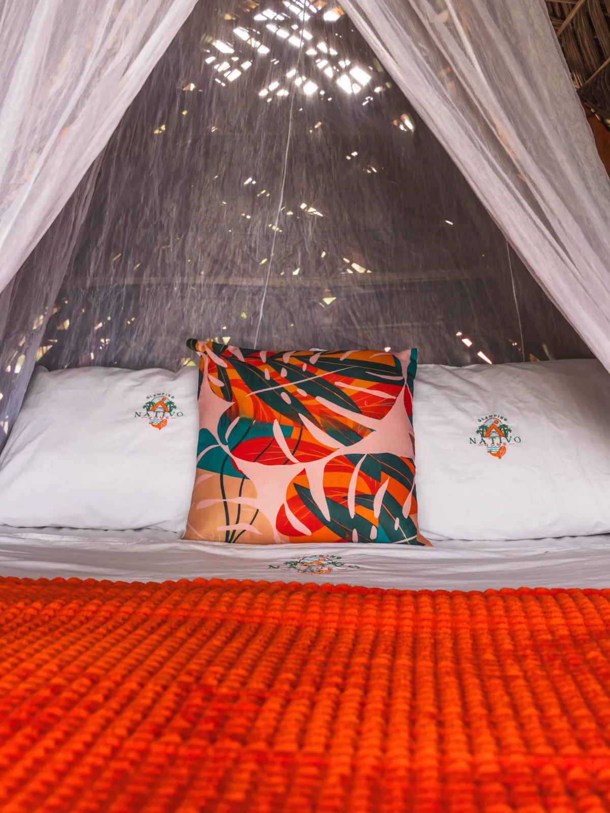 Cama doble del Mini Nativo con mosquitero, cojín tropical y cubrecama naranja