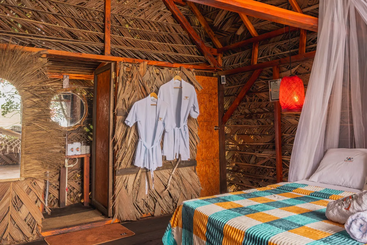 Interior del Bungalow Premium con cama, batas y baño privado